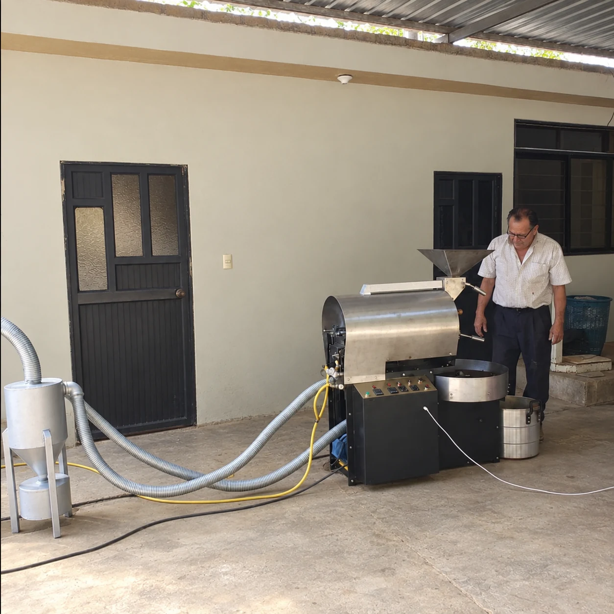 El abuelo de la familia junto a la maquinaria cafetera que diseñó y fabricó en Puyango.