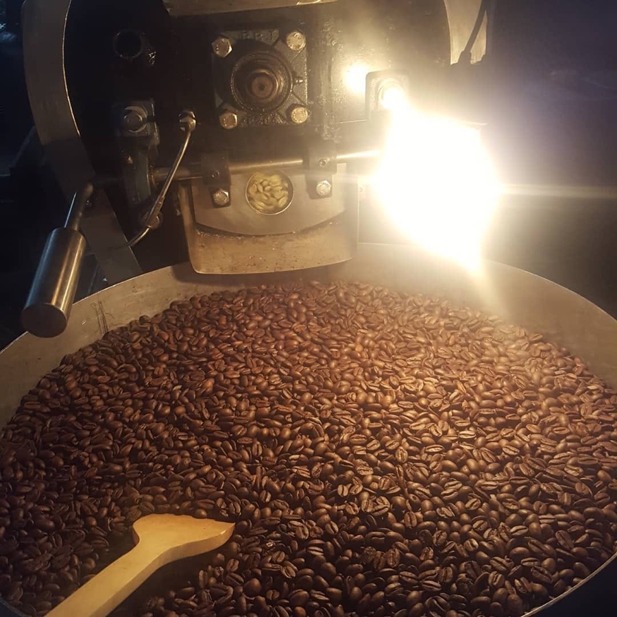 Tueste nocturno de café, granos recién salidos de la tostadora.